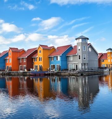 Colourful hourses over the canal in Gronigen with a cloudy sky