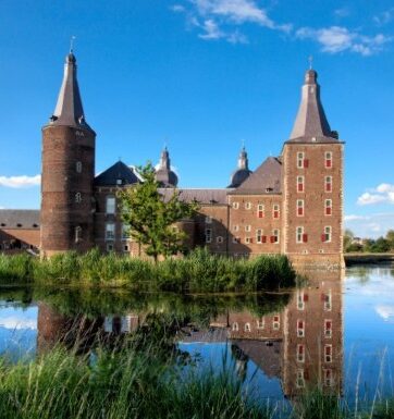 A castle and a canal in Limburg with long grass and trees