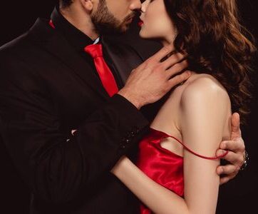 an escort kissing her client in matching red attire