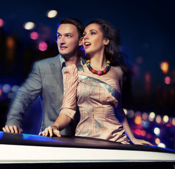 an escort and client standing in limo looking at the bright lights of the city