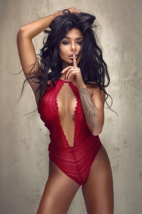 Sexy lady in lace lingerie witn long black hair looking at camera.