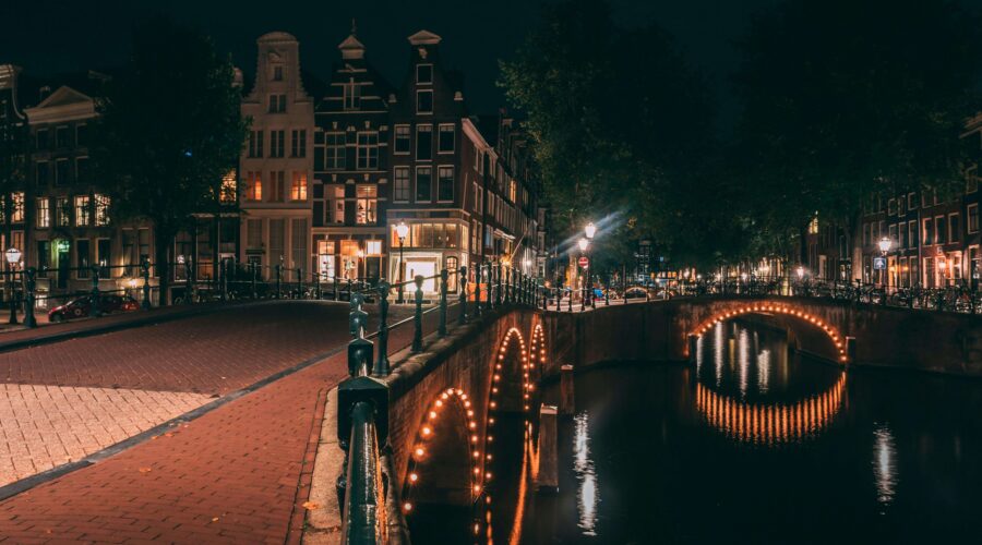 lights illuminating Amsterdam's bridge and buildings at night