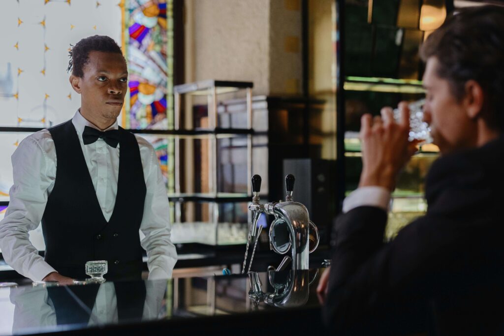 a man drinking at a bar with a bartender