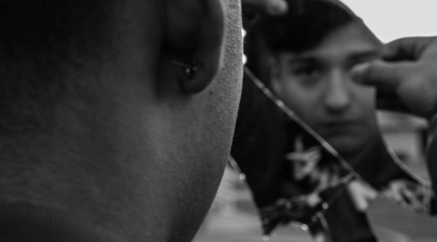 a man looking at his face in a reflection